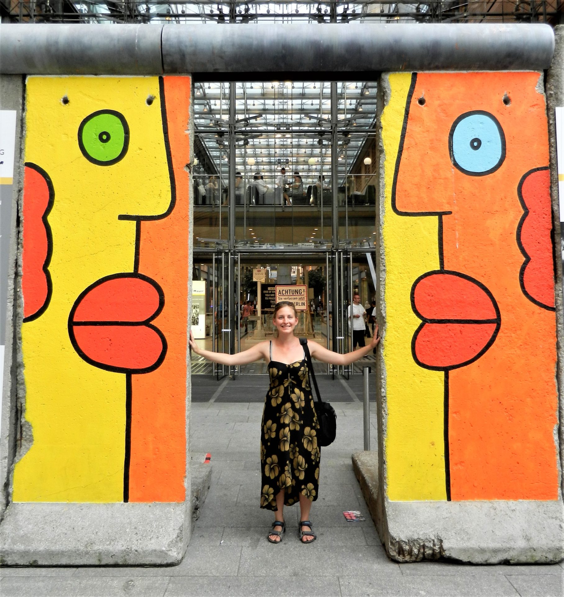 Ashleigh between two Berlin wall segments in Berlin, Germany